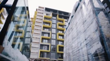 Yeni teslim edilmiş, hala ambalajlı, henüz bir inşaat binasının ön cephesine çift camlı pencereler kurulmamış. Çalışma devam ediyor