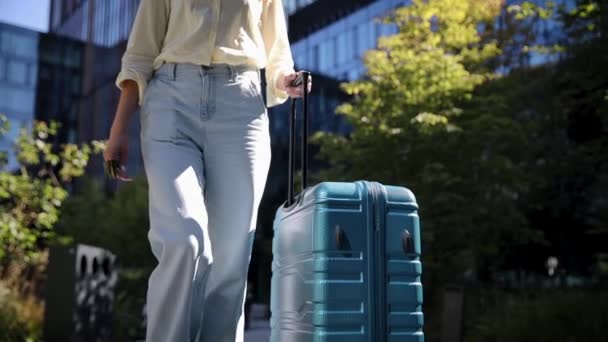 近距离观察带着车轮旅行行李的妇女 带有手柄和轮子的现代蓝色行李箱 — 图库视频影像