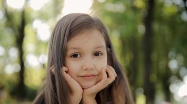 Yaz günü kameraya bakan küçük bir kızın portresi. Küçük bir çocuk 6-7 yıl çocuksu bir merakla dışarıda dolaşır. Gözlere bak, ciddi derin düşünen çocuk.