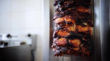 Shawarma için etli rosto, kebap ya da ateşin yanında dönen jiroskoplar. Yakın plan. Yavaş çekim görüntüleri. Kuzu eti dikey bir şişte toplanmış ve kömürlerin üzerinde kızartılıyor. Türk Mutfağı