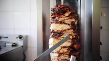 Geleneksel Türk Doner Kebabı yapmadan önce Shawarma eti kesiliyor. İstanbul, Türkiye 'de sokak yemekleri restoranında kebap etini keskin bıçakla kesen şef