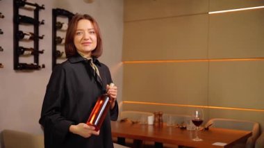 Şarap imalathanesinde şarap şişesi tutan güzel bir şarap garsonu. Özel şaraphane konsepti