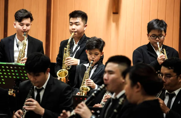 stock image group of asian people playing saxophone at the concert.