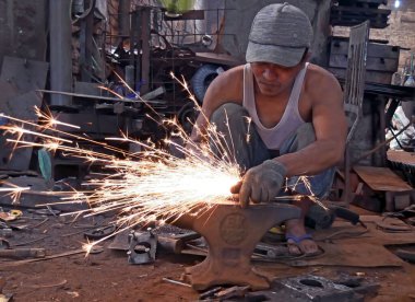 Metal bir boruyla çalışan kaynakçı.