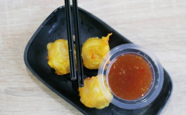 Beyaz arka planda bir kasede kızarmış balık.