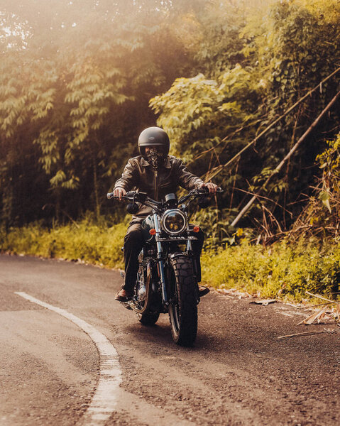 man riding a motorcycle on road 