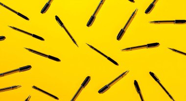 Kalemler sarı bir zemin üzerinde kaotik ama görsel olarak tatmin edici bir düzende dağılmış. Çelişkili pozisyonları rastgelelik ile oynarken aynı zamanda incelikli bir sanatsal model sunuyor..