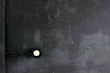 Endüstriyel siyah tavanda minimalist siyah spot ışığı. Endüstriyel mimarinin detayları. Sanayi geçmişi