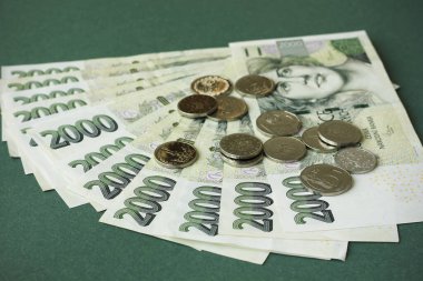 Koyu yeşil arka planda iki bin Çek banknot ve bozuk para. Çek parasına yakınlaş. Çek Cumhuriyeti konseptinde mali sorunlar.