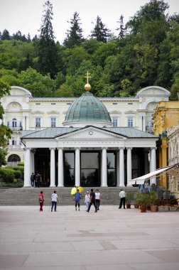Marienbad, Çek Cumhuriyeti, 16 Haziran 2023: Cross Spring Pavyonu 'na ataerkil haç taşıyan birkaç turist