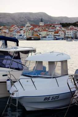 Hırvatistan, Avrupa 'nın Krk Adası' ndaki popüler turistik durak Baska köyündeki liman manzarasının üzerinde. Hırvat kıyısı açıklarında turkuaz mavi Adriyatik denizi.