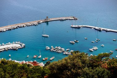 Hırvatistan, Avrupa 'nın Krk Adası' ndaki popüler turistik durak Baska köyündeki liman manzarasının üzerinde. Hırvat kıyısı açıklarında turkuaz mavi Adriyatik denizi.