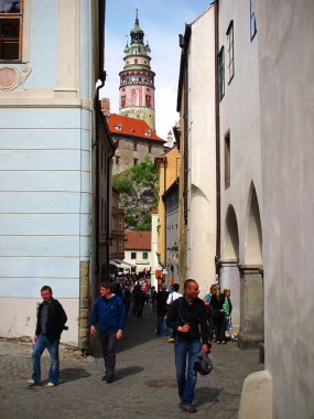 Cesky Krumlov, Çek Cumhuriyeti - 04: 30 2011: Arka planda Cesky Krumlov şatosunun güzel rönesans kulesi ve ön planda eski burgher evleri ve turistler, Güney Bohemya.