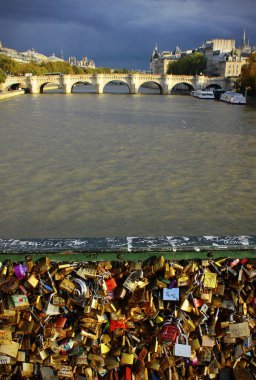Paris, Fransa - 10: 26 2013 Pont des Arts köprüsünden Pont Neuf köprüsüne ve Seine nehrine bulutlu bir gökyüzü altında turist botlarıyla asılmış bir korkulukla manzara