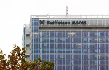 Prag, Çek Cumhuriyeti - 4 Kasım 2024: Prag Pankrac 'taki Raiffeisen banka genel merkezi, Prag' daki Raiffeisen bankasının genel merkezi olan şirket adı ve logosu Pankrac 'ta sonbahar yapraklı akçaağaç dalları.