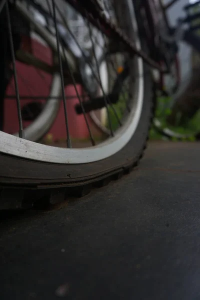 flat bicycle tire in front of the house in the morning