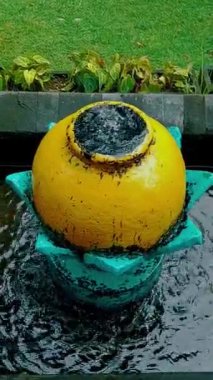 fish pond with a yellow jug decoration that emits water in the middle