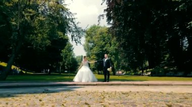 Parkta düğün dansı. Yeni evliler el ele tutuşurken U dönüşü yapıyorlar. Düğün dansı elementi