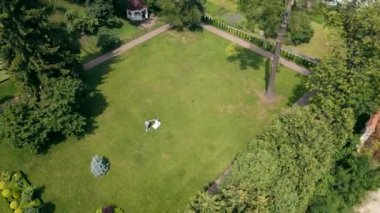 Gelin ve damadın havadan görünüşlü dansı yeşil bir çimenlikte yüksekten. Yeni evlilerin ilk dansı..