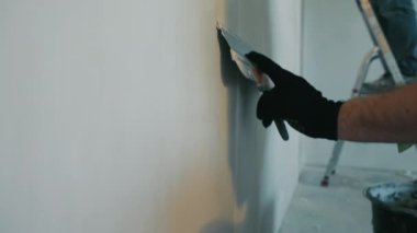 Bir apartman yöneticisi dairenin tamiratını yapar. Uzman ressamlar ve sıvacılar duvarları kaplar..