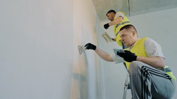 有两位主人正在从事公寓的修理工作 专家是在公寓墙壁上涂膏药的画家和美容师 — 图库视频影像