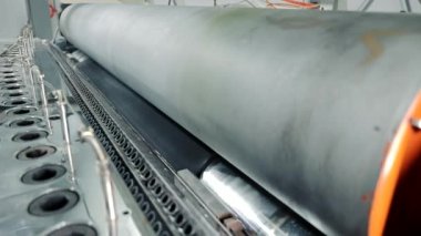 Otomatik lastik baskı makinesi. Lastik ürünleri işleme fabrikası. Kauçuğun sıcaklığının altında büyük bir şaftla yakın çekim.