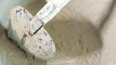 Kovada çimentoyu yakın plan kürekle karıştırmak.