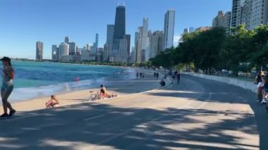 Chicago, Illinois, ABD - 05.10.2022 Lakefront Trail 'de kalabalıklar arasında bisiklet sürmek. Güneşli bir günde Michigan rıhtımında bisiklet sürmek.