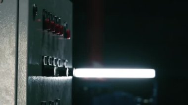 Karanlık bir odada endüstriyel başlatma ya da durdurma düğmesi. Cihazı erkek eliyle açıp kapatma