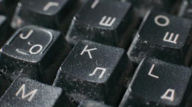 Close-up of an old keyboard in a dilapidated state. Dirty keyboard with Latin and Cyrillic letters