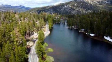 A beautiful landscape of the highlands and the road along which the car moves near the lake. The nature of the highlands. Tourist route near the lake