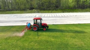 Aerial view spraying the field with water and an agrochemical solution to improve grass growth