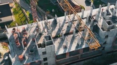 Drone Aerial Top View Of Construction Work, Top View Through A Construction Crane. Builders Build A House. Construction Work