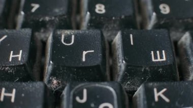 Close-up of an old keyboard in a dilapidated state. Dirty keyboard with Latin and Cyrillic letters