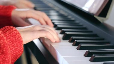 Teacher and student playing the piano. Learning to play the piano. Close-up of hands and keys