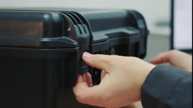 The master opens the large black box with his hands. The box is being opened