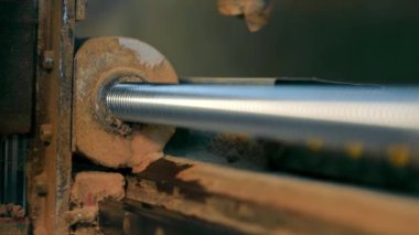 A ball screw that rotates between the screw axis and the nut on a CNC machine close-up.