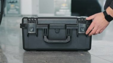 The Mechanic Opens A Large Black Tool Box. Close-up Of A Hand Opening A Box