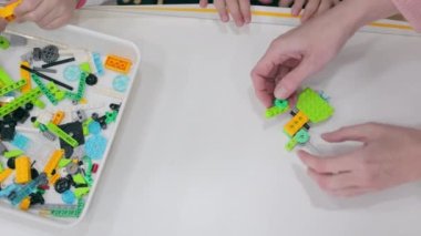 Children Play With Lego And Create Programmable Robots. Close-up Of Robotics