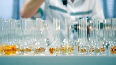 Araştırmacı daha fazla araştırma için test tüplerine çözümü ekler. Laboratuvarda kimyasal reaksiyonlar karıştırılıyor.
