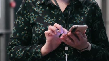 Bir kadın cep telefonuyla yakından çalışıyor. Kadınların elleri ve telefonları yakın çekimde.