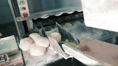 Ekmek üretim hattı. Hamurdan ekmek yapmak. Hamuru otomatikman üretim hattına aktarmak.