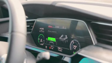 Araba kullanırken elektrikli bir arabanın gösterge paneli. Arabanın hareketleri hakkında bilgi içeren hız göstergesi ve takometresi