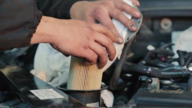 Bir dizel arabanın yakıt filtresi değiştiriliyor.