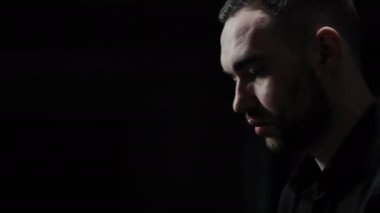 Piyano çalan bir piyanistin yüzü. Piyano çalarken bir erkeğin duyguları. Karanlık bir odada bir yüzün yakın çekimi, profil görünümü