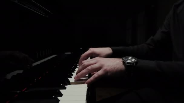 ピアニストの手のクローズアップ 音楽家が暗いホールでピアノを演奏する プロのピアニストがピアノを弾く — ストック動画
