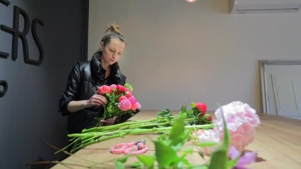 Μια Νεαρή Γυναίκα Ανθοπώλης Ετοιμάζει Ένα Μπουκέτο Λουλούδια Ένα Κατάστημα — Αρχείο Βίντεο