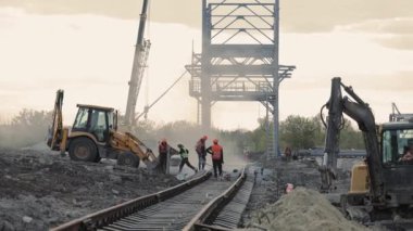 Demiryolu İnşaat. Uzmanlar pist yatağı üzerine kurulum çalışmaları yürüttüler. Kazıcı Yıkıntıyı Dolduruyor