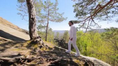 Beyaz elbiseli bir adam yükseliyor. Turist Tatil Yürüyüşü Zirveye Çıktı