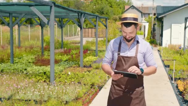 Beyaz Erkek Bahçıvan Bahçe Merkezinde Tablet Üzerinde Çalışıyor Çiçekçide Çalışıyorum — Stok video